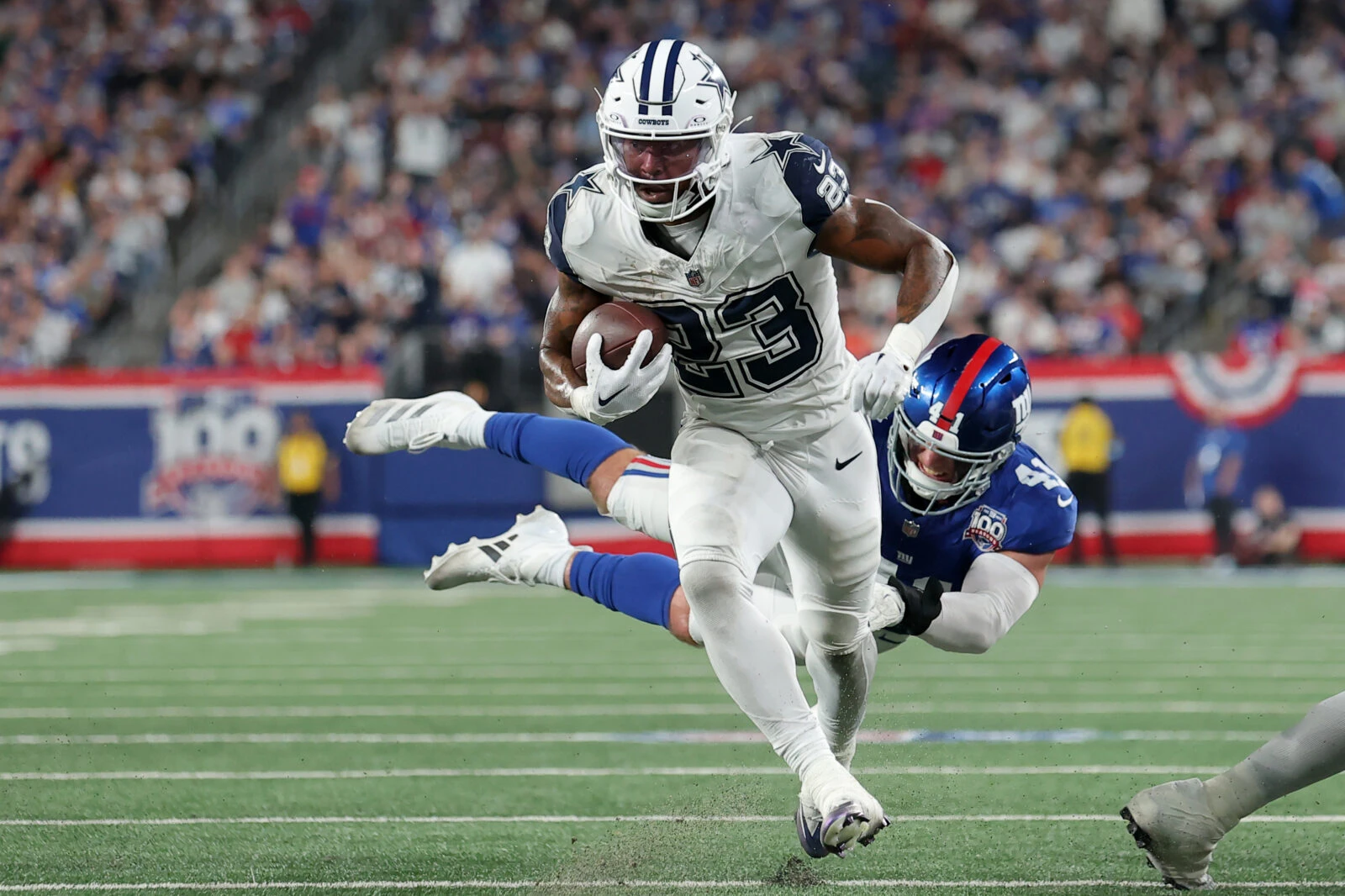 Sep 26, 2024; East Rutherford, New Jersey, USA; Dallas Cowboys running back Rico Dowdle (23) runs for a touchdown against New York Giants linebacker Micah McFadden (41) during the first quarter at MetLife Stadium.